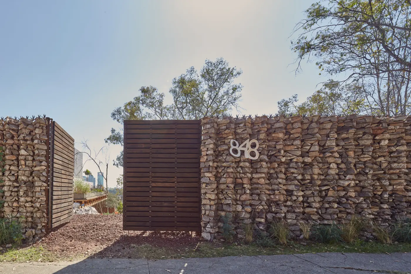 El muro de gaviones en el acceso, con el número 848
